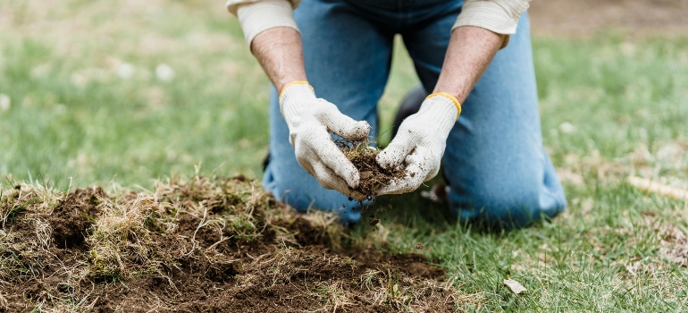 Osoba primenjuje fizičke mere suzbijanja korova.