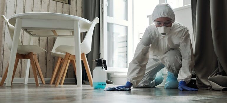 Osoba u zaštitnoj opremi sprovodi higijenski tretman poda u modernom prostoru, ilustrujući šta je deratizacija u okviru profesionalne zaštite objekta.